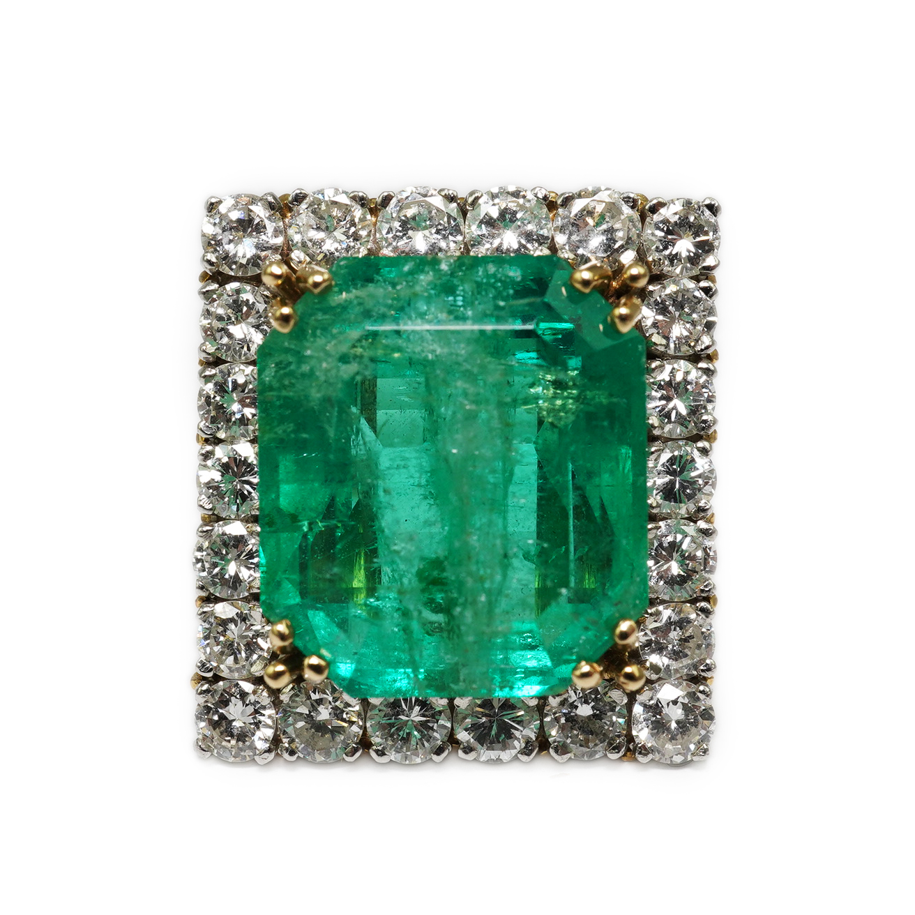 A Stern 18ct white and yellow gold, emerald and diamond dress ring, the central green emerald cut emerald approximately 8.0ct and surrounded by twenty two circular cut diamonds, approximately 2.7ct total